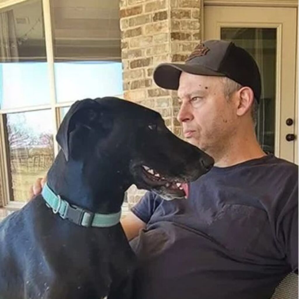 A man and a black dog